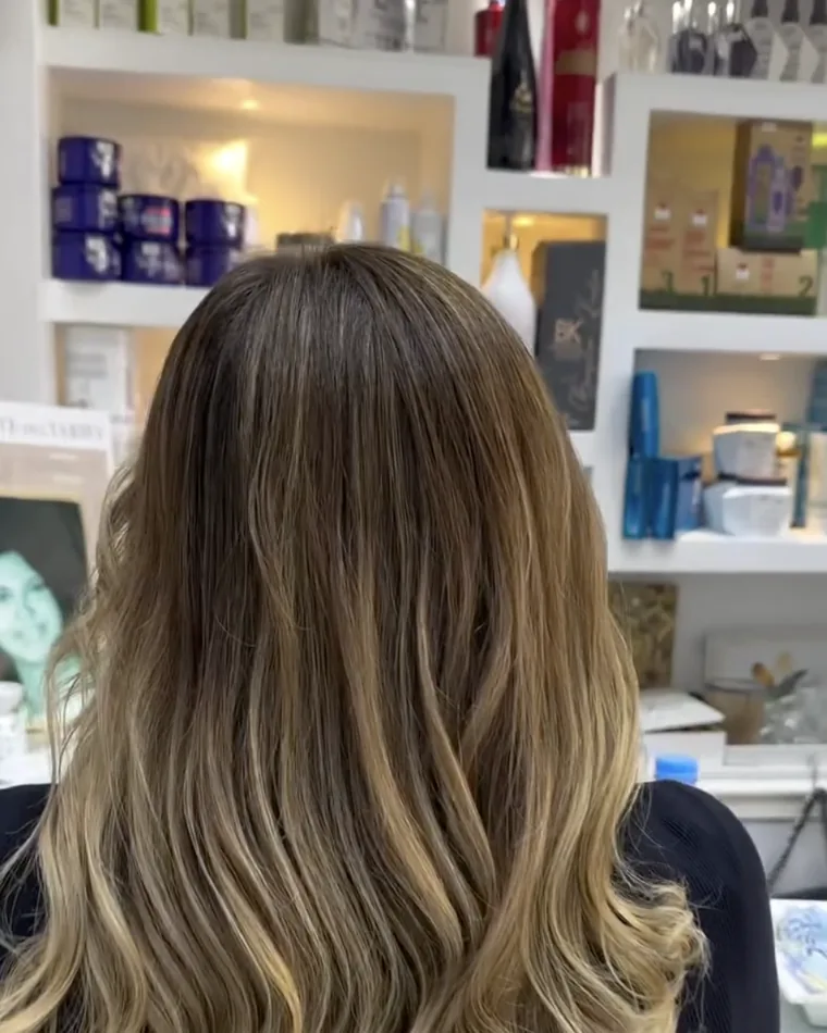 Balayage brun aux reflets beige blond réalisé au salon